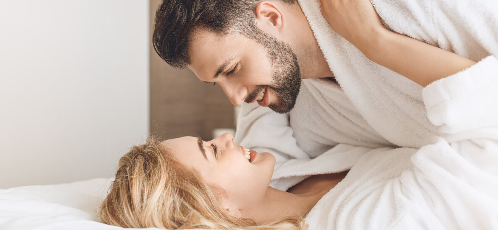 Cuplu zâmbind după sex în pat